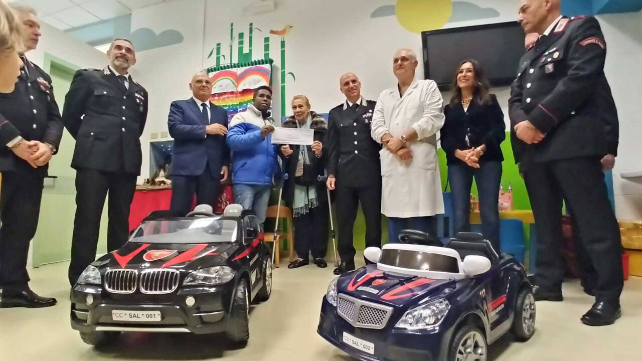 Le due mini auto, i carabinieri, il direttore generale e le Patronesse nella sala giochi del Salesi