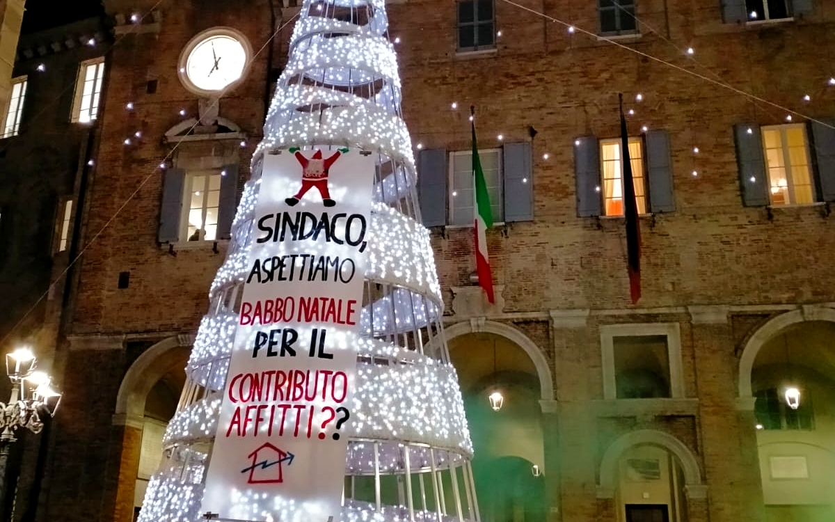 Lo striscione sul contributo affitti appeso all'albero di natale in piazza Roma a Senigallia